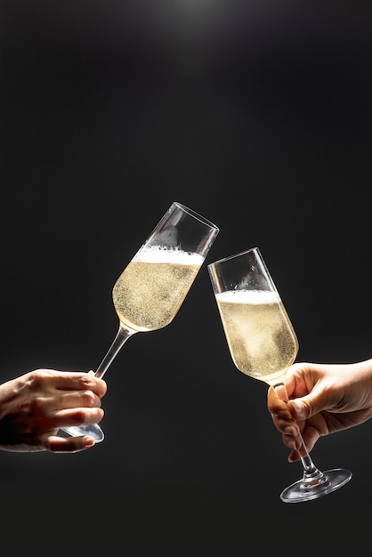 Couple celebrating with champagne on dark background