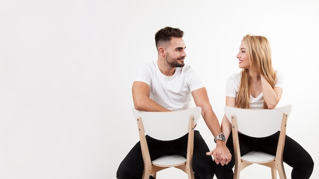 Couple on chairs holding hands