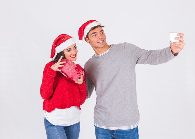 Couple in Christmas hats taking selfie 