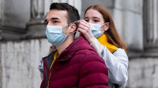 Couple in the city wearing medical masks together