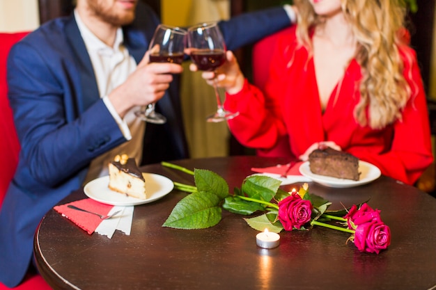 Couple clanging glasses at table in restaurant