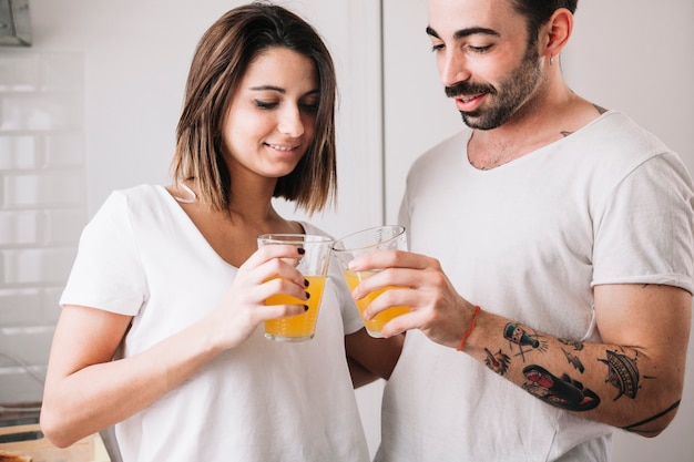 Free photo couple clinking glasses with juice