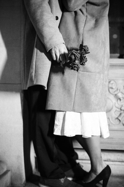 Couple in coats kissing leaning on wall of building