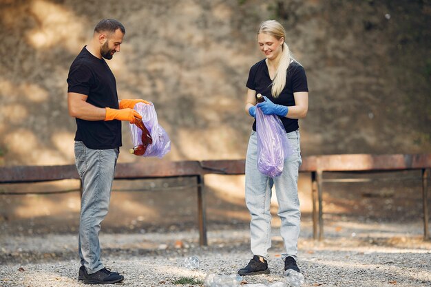 Couple collects garbage in garbage bags in park