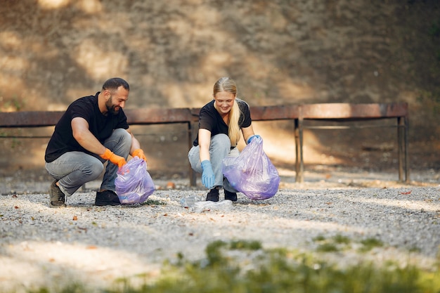 Couple collects garbage in garbage bags in park