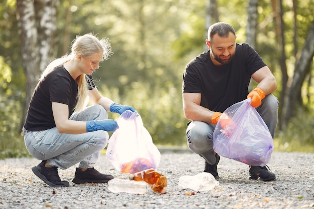 Free photo couple collects garbage in garbage bags in park