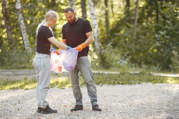 Couple collects garbage in garbage bags in park