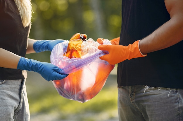 Free photo couple collects garbage in garbage bags in park