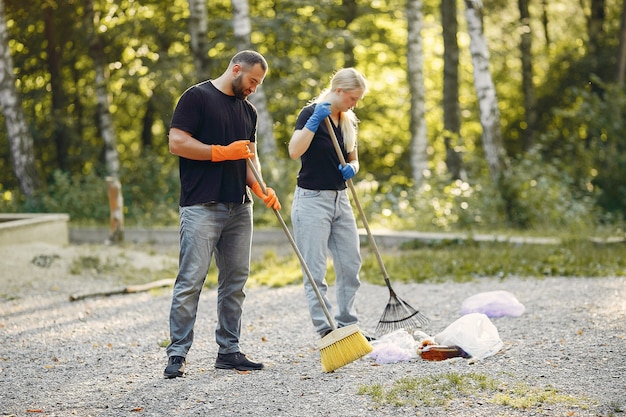 Couple collects garbage in garbage bags in park