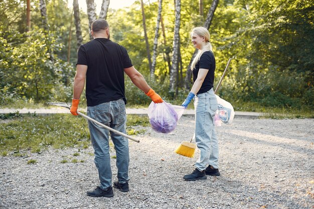 Couple collects garbage in garbage bags in park