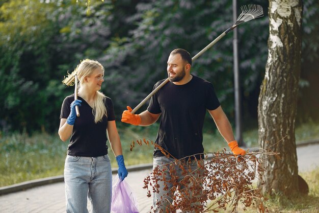 Couple collects leaves and cleans the park