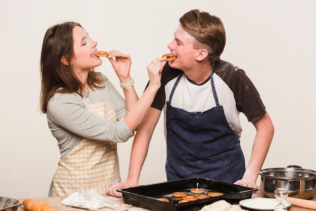 Free photo couple cooking together and tasting pastry