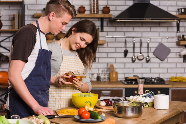 Couple cooking vegetarian salad with fresh vegetables