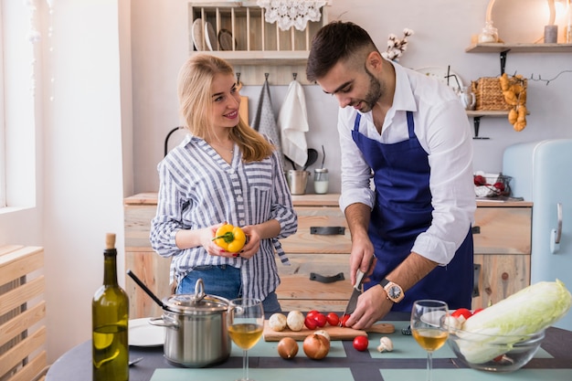 Free Photo couple cutting vegetables for salad on wooden board