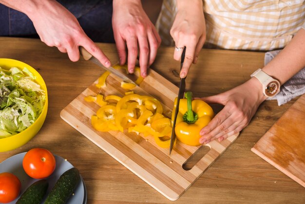 Couple cutting yellow pepper for salad 