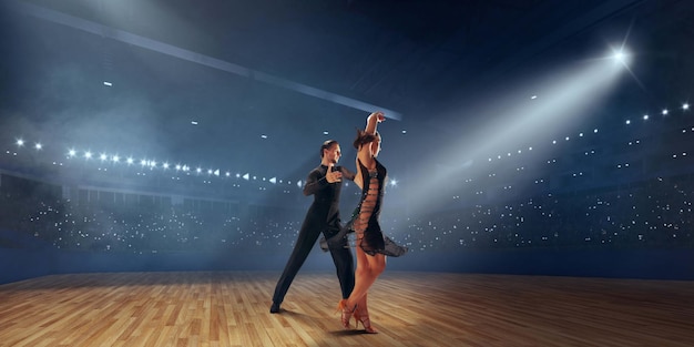 Free Photo couple dancers perform latin dance on large professional stage ballroom dancing