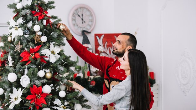 Couple decorating Christmas tree