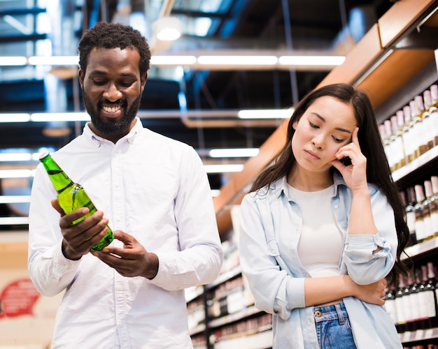 Couple disagreeing about beer at grocery store