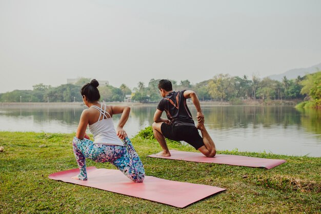 Couple doing yoga with a beautiful landscape