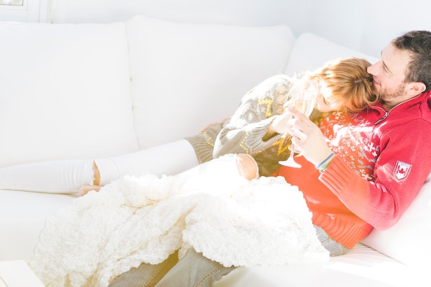 Couple drinking champagne and resting on couch