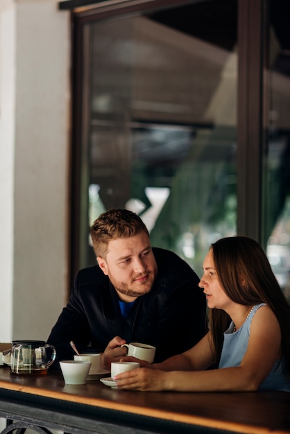 Couple drinking coffee and talking in coffee shop