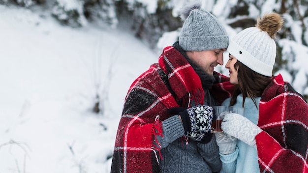 Couple drinking tea in winter forest