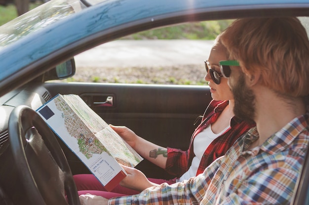 Free photo couple driving and looking at map