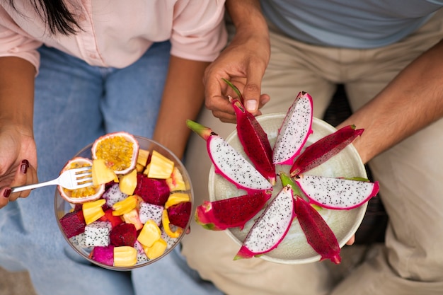 Couple eating dragon fruit outdoors together