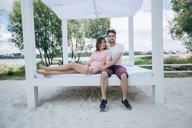 Free photo couple embracing on a double bed at the beach