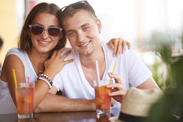 Free Photo couple embracing and drinking a soft-drink