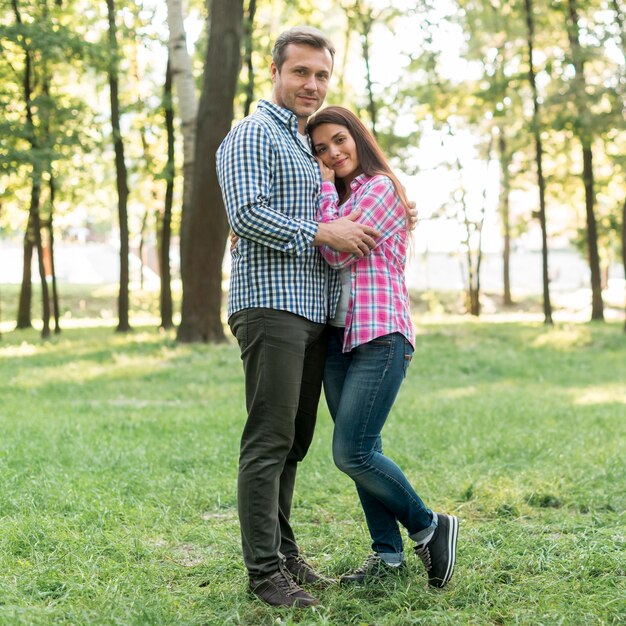 Couple embracing and looking at camera in garden