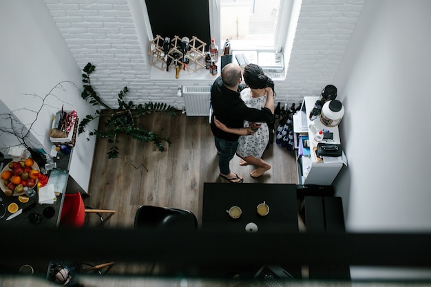 Free photo couple embracing looking out of window as seen from above