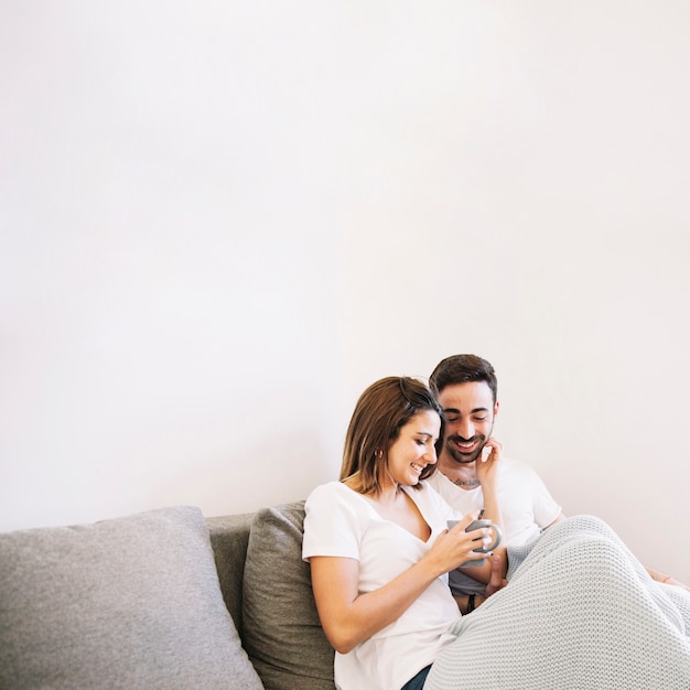 Couple enjoying drink on sofa