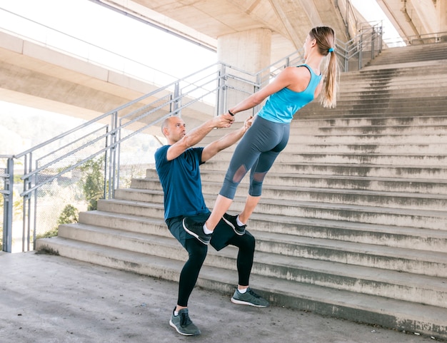 Free photo couple exercising workout fitness aerobics posture near the staircase