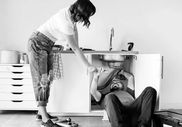 Couple fixing kitchen sink