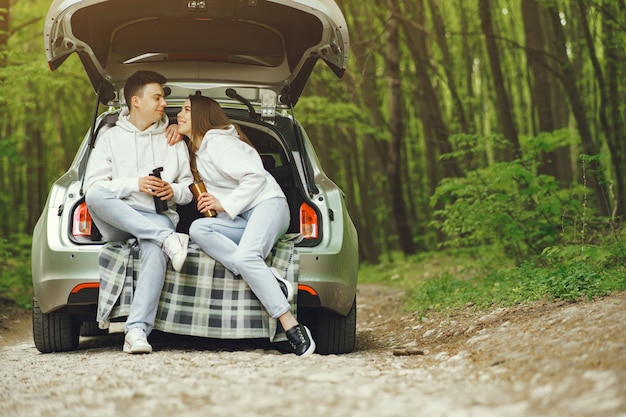 Free photo couple in a forest sitting in a trunk