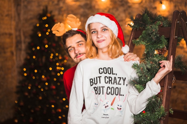 Free photo couple in front of christmas tree