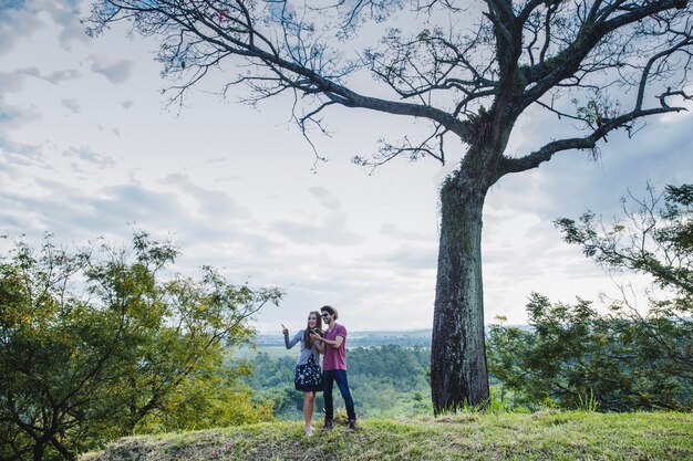 Couple in front of a tree on a hill