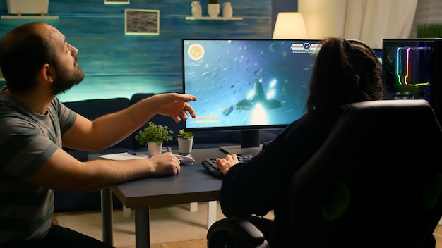 Free photo couple of gamers losing space shooter tournament while playing in room with rgb