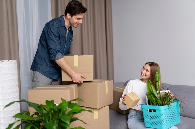 Couple handling boxes of belongings after moving in a new house