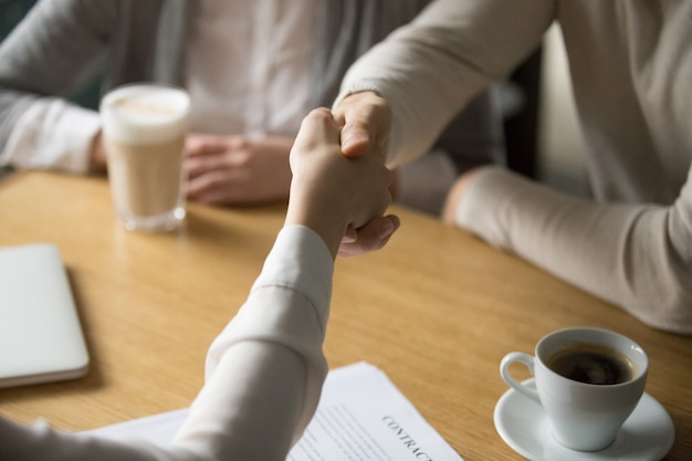 Free photo couple handshaking businesswoman making deal in cafe, close up view