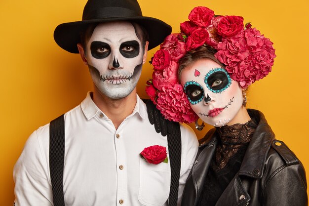 Couple have painted faces, take part in zombie walk, commemorate dead during Day of Death in Mexico, wears halloween party makeup