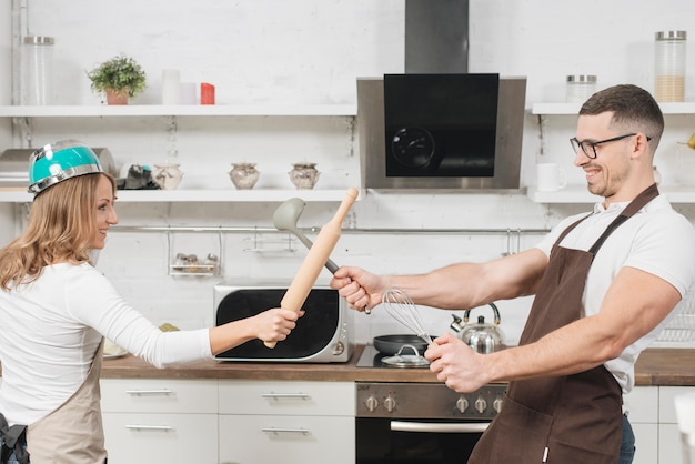 Couple having fun fight in kitchen