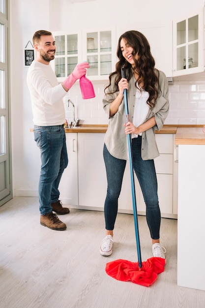 Free photo couple having fun while cleaning kitchen