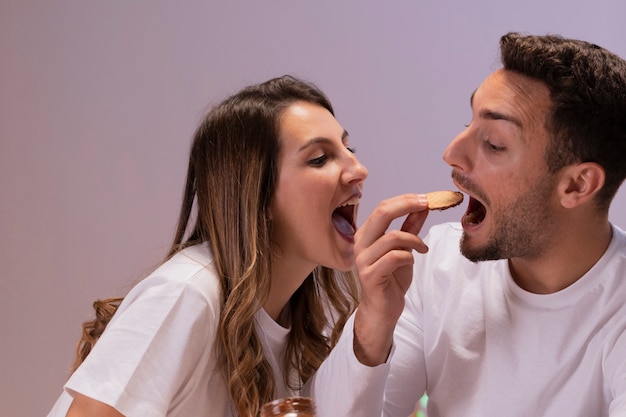 Couple having fun with biscuits