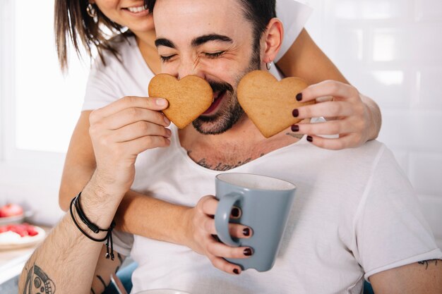 Couple having fun with heart cookies