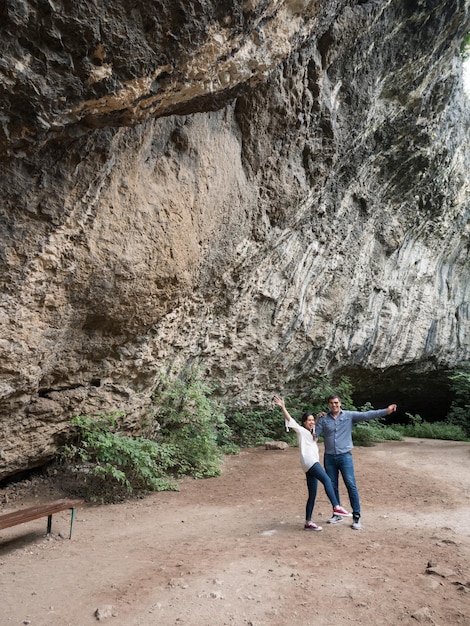 Free photo couple having a good time away from the city exploring a cave in the mountains. happy couple in nature.