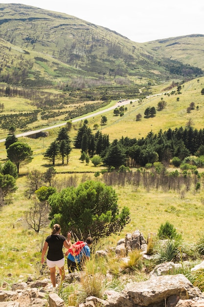 Free photo couple hiking on stone hill near valley