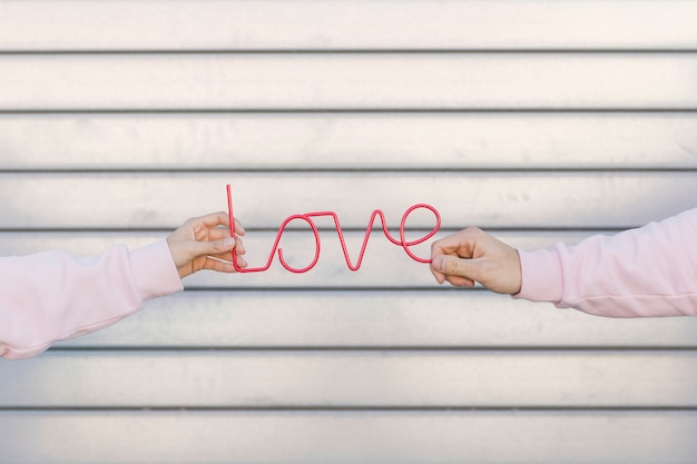 Free Photo couple holding decorative love sign