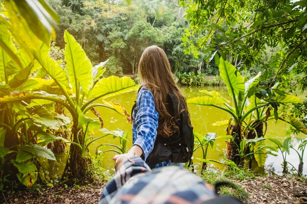 Couple holding hands and going towards a forest